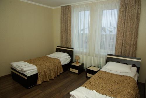 Habitación de hotel con 2 camas y ventana en Hotel Deluxe, en Horodenka