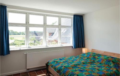 ein Schlafzimmer mit einem Bett und zwei Fenstern in der Unterkunft Ferienhaus Gammelby Dorfstr. II in Gammelby