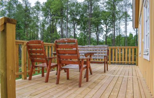 two chairs and a table on a wooden deck at Holiday Home Gullabo 06 in Gullabo