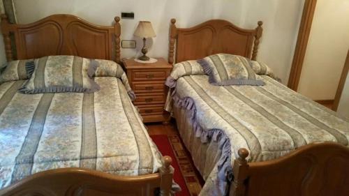 two beds sitting next to each other in a bedroom at Hostal La Parra in Vegadeo