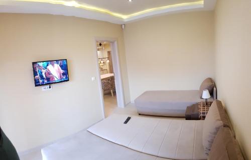ein Schlafzimmer mit einem Bett und einem TV an der Wand in der Unterkunft Apartments Exclusive in Belgrad