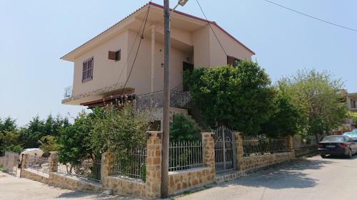 a house with a fence in front of it at Stone house with seaview in Nea Potidaea