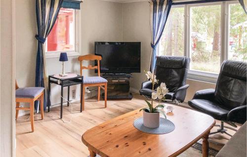 モンステロアスにあるHoliday Home Eklekärsvägen Mönsteråsのテーブルと椅子とテレビのあるリビングルーム