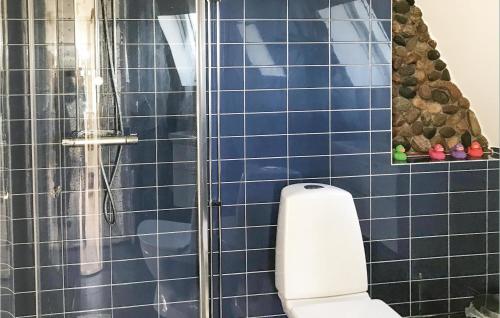 a blue tiled bathroom with a shower and a toilet at Stunning Home In Degerhamn With Wifi in Gammalsby