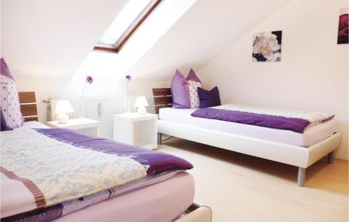twee bedden in een kamer met paars en wit bij 2 Bedroom Nice Apartment In Bad Pyrmont in Bad Pyrmont
