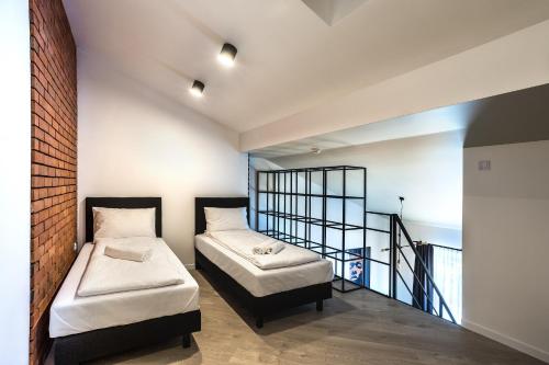 two beds in a room with a balcony at Apartamenty Nowa Kamienica Częstochowa Centrum Szymanowskiego 22A in Częstochowa