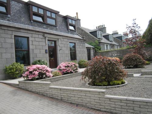 a brick house with flowers in front of it at Beeches Aberdeen in Aberdeen