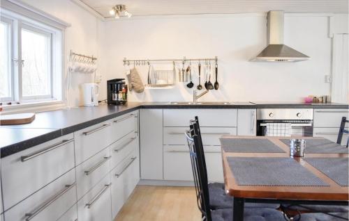 a kitchen with white cabinets and a wooden table at 2 Bedroom Gorgeous Home In Jämjö in JÃ¤mjÃ¶