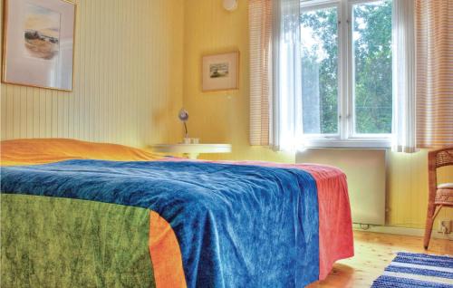 a bedroom with a bed with a blue blanket at Stunning Home In Frjestaden With 2 Bedrooms And Wifi in Färjestaden