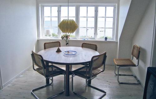 a table and chairs in a room with a window at Holiday Home Fiskarevägen Abbekås Ii in Abbekås
