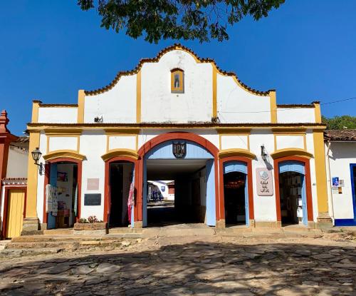 - un bâtiment blanc avec une arche dans une rue dans l'établissement Hotel Ponta do Morro, à Tiradentes