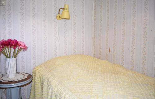 a bedroom with a bed and a vase of flowers on a table at Holiday Home Rökulla Mariannelund in Mariannelund