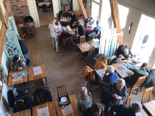 a group of people sitting at tables in a restaurant at Mellomgården in Norra Lundby