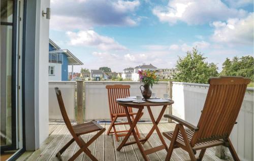 a patio table and chairs on a balcony with a view at Amazing Apartment In Börgerende in Börgerende-Rethwisch