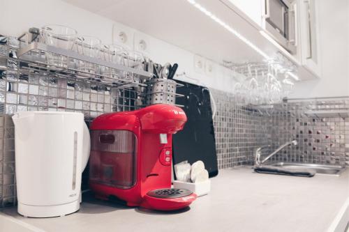 un appareil rouge assis au-dessus d'un comptoir de cuisine dans l'établissement Ternes Cozy Studio, à Paris