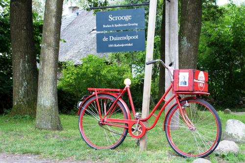 a red bike is parked next to a sign at The Barnyard in Balinge