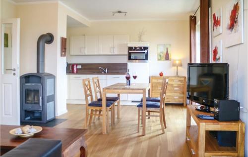 a living room with a table and a stove at Amazing Apartment In Börgerende in Börgerende-Rethwisch