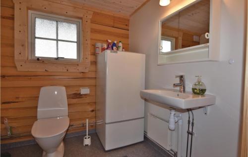 uma casa de banho com um WC, um lavatório e um frigorífico em Nice Home In Grums With Kitchen em Västra Malsjö