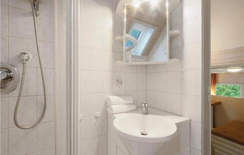 ein weißes Bad mit einem Waschbecken und einer Dusche in der Unterkunft Ferienhaus 87 In Kirchheim in Kemmerode