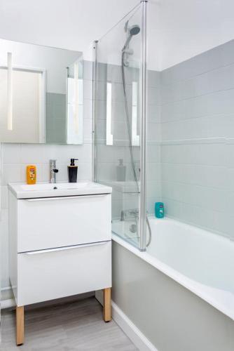 une salle de bain blanche avec un lavabo et une douche dans l'établissement LA MAISON DU BONHEUR, à Rouen