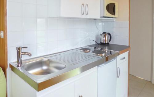 a kitchen with a sink and a stove at Nice Home In La Chapelle En Juger With 1 Bedrooms And Wifi in Montreuil-sur-Lozon