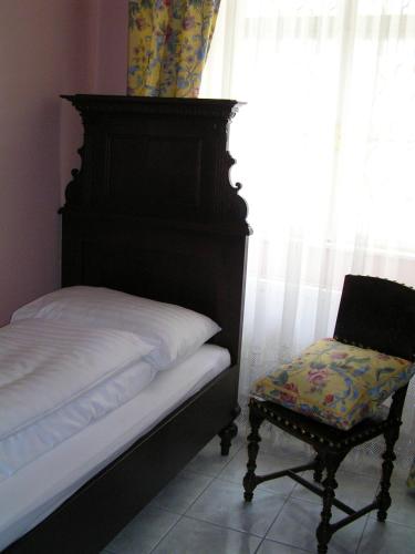 a bed and a chair in a room with a window at Boutique Hotel Ur-Wachau in Weissenkirchen in der Wachau