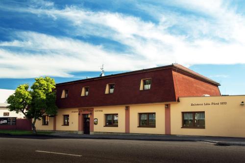a brown and white building on the side of a street at Penzion Na Netřebě in Pardubice