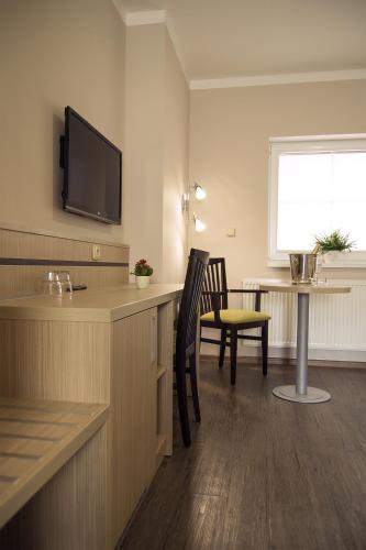 a room with a kitchen with a table and a television at Penzion Na Netřebě in Pardubice