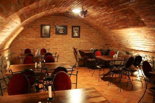 un restaurant avec des tables et des chaises et un mur en briques dans l'établissement Pas Stefą, à Telšiai