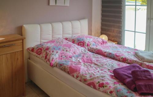 Una cama con edredón rosa y blanco. en Gorgeous Apartment In Warnemnde With Kitchen, en Warnemünde