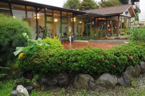 a house with a garden in front of it at Lotus Hostel Beicheng Zhuang in Luodong