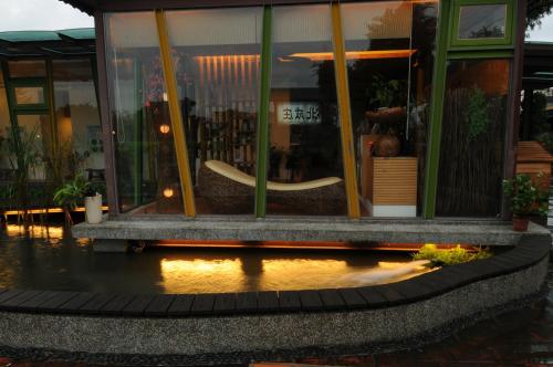 a store front with a reflection in the water at Lotus Hostel Beicheng Zhuang in Luodong