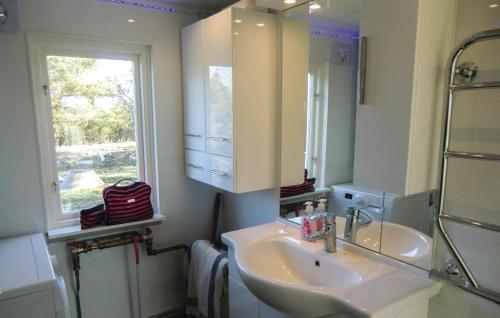 ein Bad mit einem Waschbecken, einem Spiegel und einem Fenster in der Unterkunft Stunning Home In Lttorp With Wifi in Löttorp