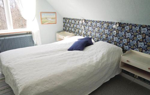 a bedroom with a large white bed with a blue headboard at Holiday Home Gunnarstorp Vessigebro in Vessigebro