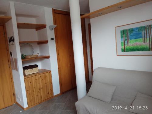 ein Wohnzimmer mit einem Sofa und einem Tisch in der Unterkunft Bilocale Fronte Piste - Appartamentiflarida Sansicario Alto in San Sicario