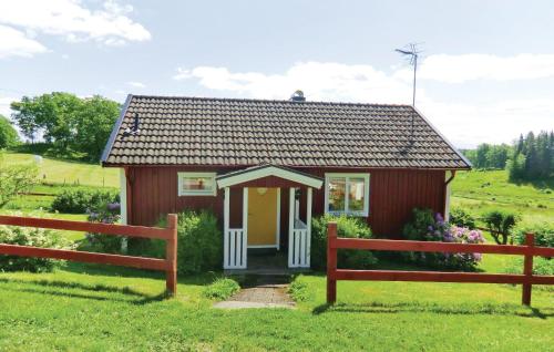 a small house in a field with two benches at Stunning Home In Landsbro With Kitchen in Landsbro