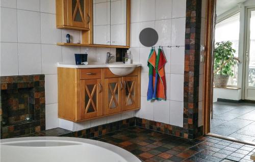 a bathroom with a sink and a tub at Villa Adens in Åsa