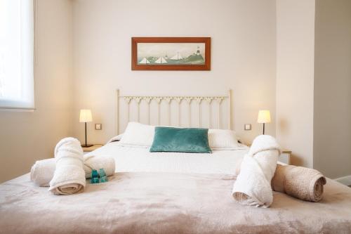 a bedroom with a white bed with towels on it at San Mames View Apartment in Bilbao