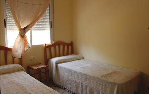 プレヤス・デ・オリフエラにあるCozy Home In Orihuela Costa With Outdoor Swimming Poolのベッドルーム1室(ベッド2台、窓付)