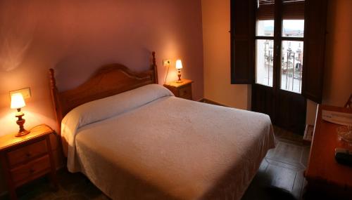 a bedroom with a white bed and two lamps at Alojamientos Plaza Mayor in Trujillo