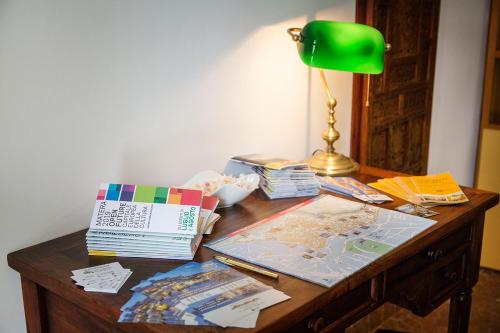 a desk with a green lamp and books on it at Umbra Idris Holiday Home in Matera