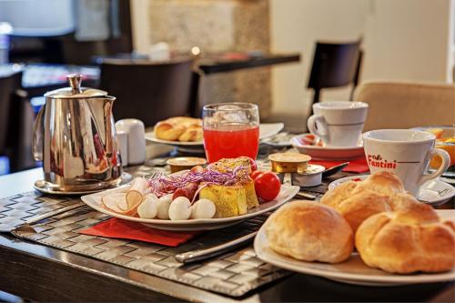 a table topped with plates of food and pastries at Dharma Luxury Hotel in Rome