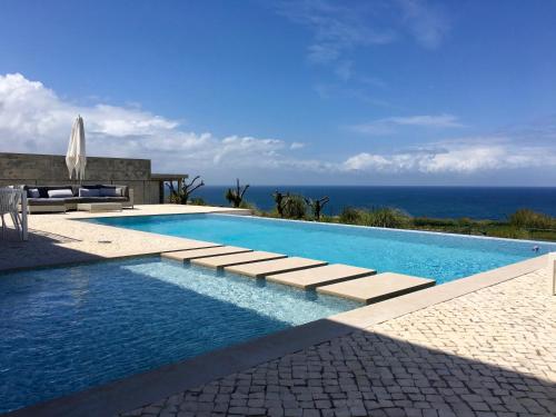 a swimming pool with a view of the ocean at ALYNES in Areia Branca