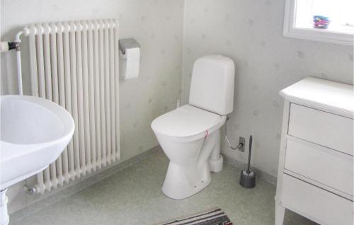 a white bathroom with a toilet and a sink at Nice Home In Korsberga With 1 Bedrooms in Korsberga