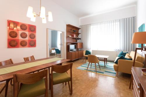 una sala da pranzo e un soggiorno con tavolo e sedie. di Vintage Design Apartments a Vienna