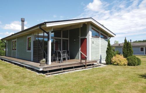 a green tiny house with a porch and a deck at Holiday Home Gärsnäs Xciii in Gärsnäs