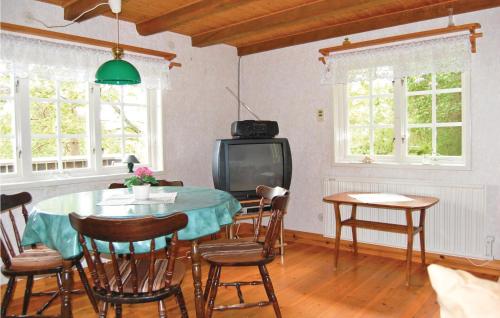 a dining room with a table and a tv at Holiday Home Loaklev Vetlanda Ii in Loaklev