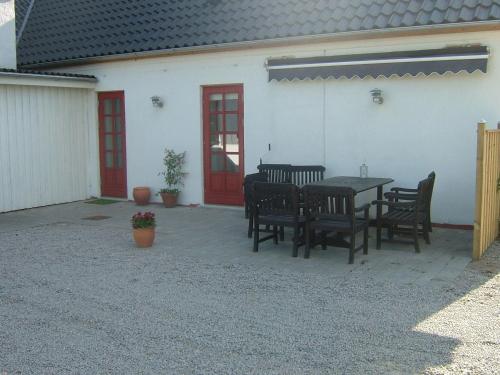 a patio with a table and chairs in front of a building at Skjoldbjerg Garnihotel in Vorbasse