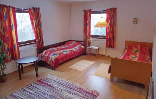 Cette chambre comprend un lit, une table et deux fenêtres. dans l'établissement Cozy Home In Korsfjorden With House A Mountain View, à Komagfjord