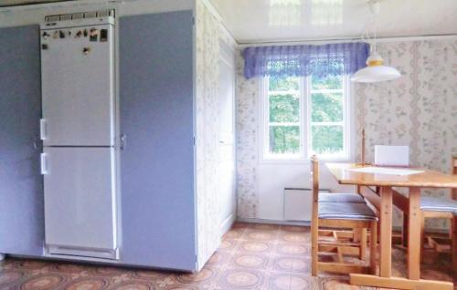 RydにあるAmazing Home In Ryd With 2 Bedroomsのキッチン(冷蔵庫、テーブル付)、窓が備わります。